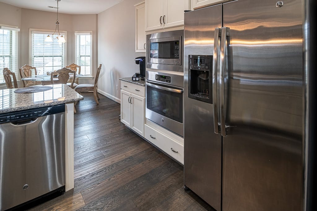 Spacious modern kitchen featuring stainless steel appliances and a dining area.